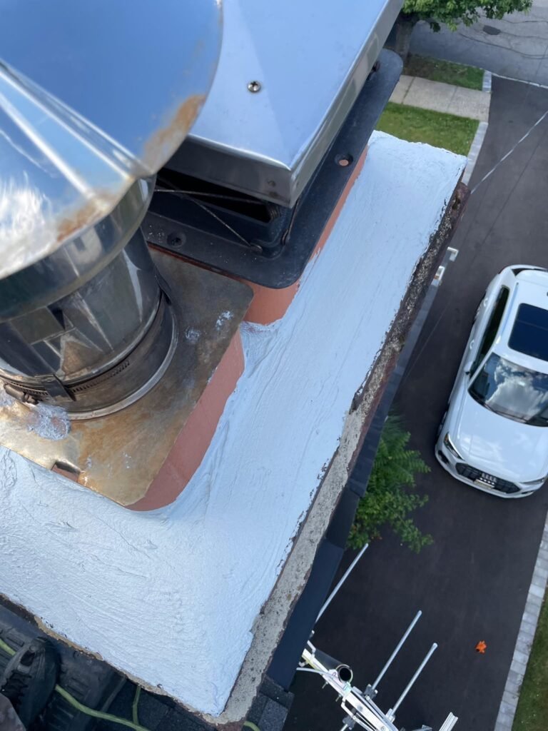 Close-up of a resurfaced white chimney crown with a metal cap, seen from above, Montclair, NJ