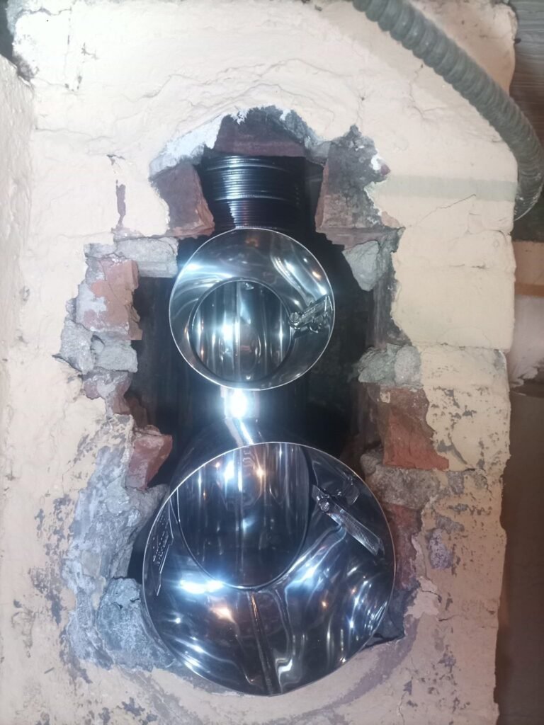 Close-up of a stainless steel liner connection set into the brick chimney, Jersey City, NJ