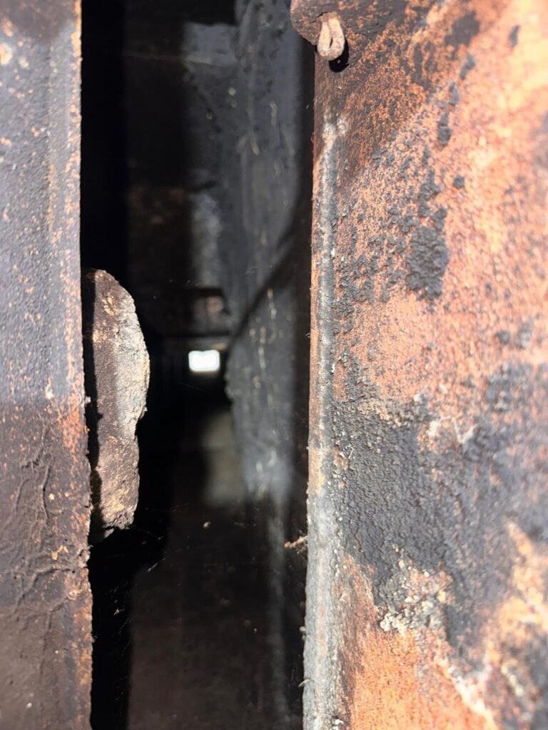Close-up of rusted, corroded metal inside the smoke chamber