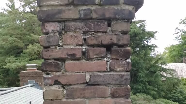 Brick chimney with weathered mortar joints and darkened brick