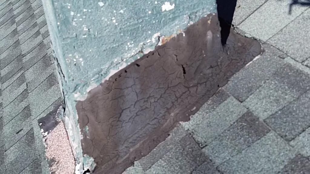 Cracked, dried flashing sealant at the base of the chimney