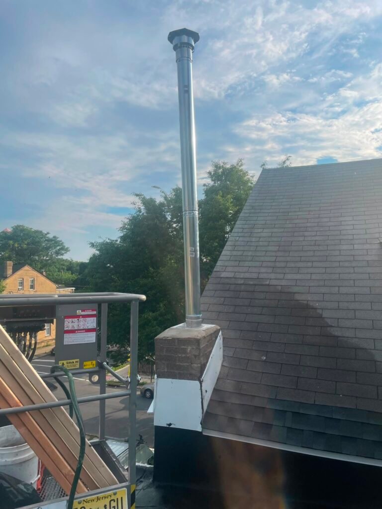 New metal flue pipe with flashing on the chimney top, seen from the roof