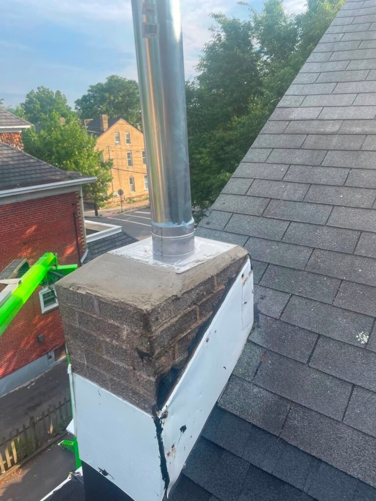 Chimney top with a stainless steel flue pipe and metal flashing